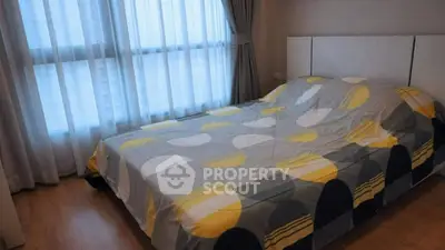 Cozy bedroom with large window and modern decor in a stylish apartment.