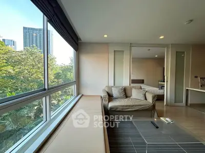 Modern living room with large windows and city view, featuring cozy seating and stylish decor.
