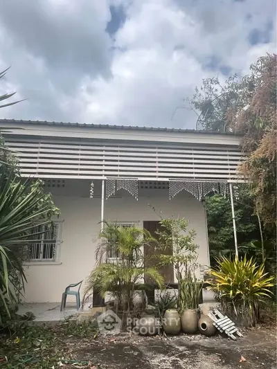 Charming single-story home with lush garden and modern facade, perfect for tranquil living.
