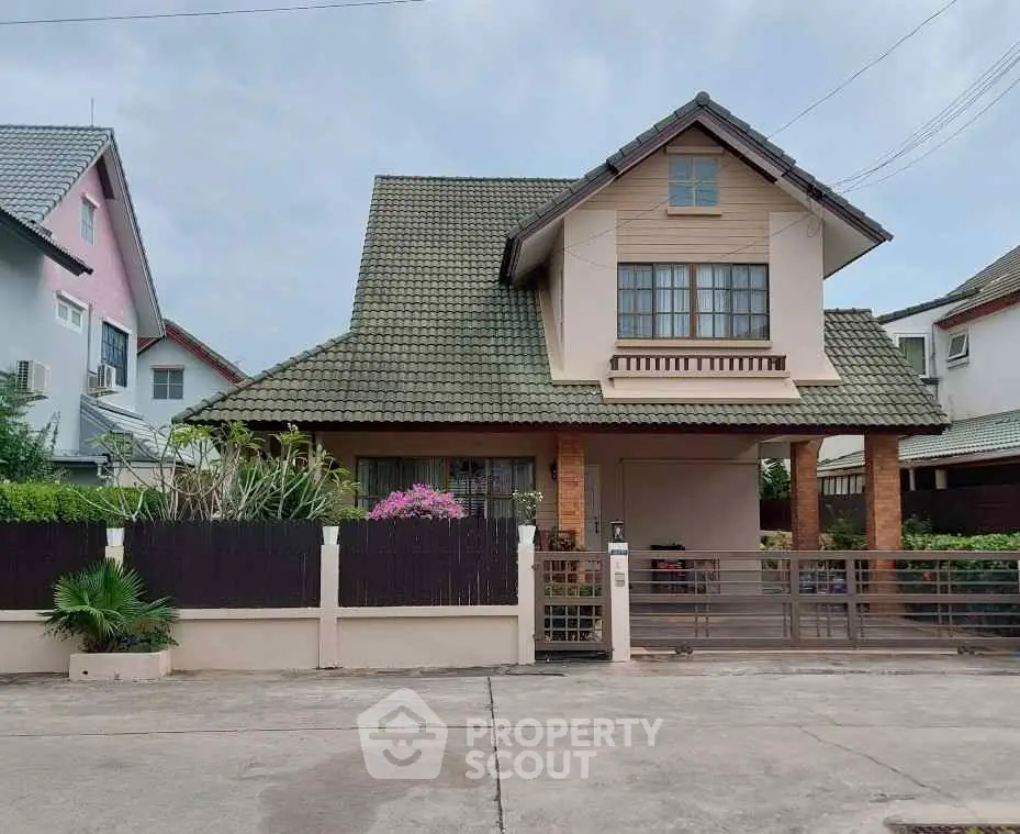 Charming suburban house with a gabled roof and fenced front yard, perfect for family living.