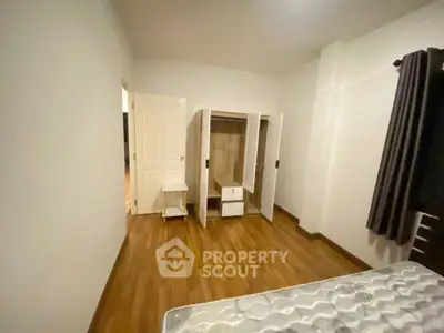 Spacious bedroom with wooden flooring and wardrobe, ideal for cozy living.