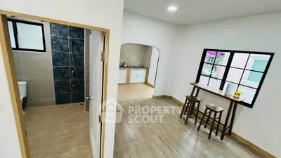 Spacious open-plan living area with modern kitchen and stylish bathroom, perfect for contemporary living.