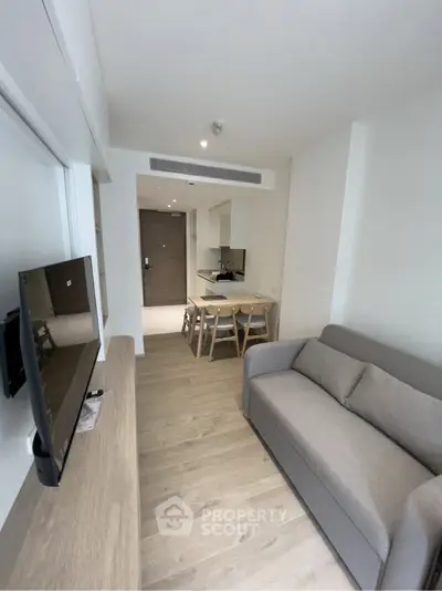 Modern living room with sleek furniture and open kitchen layout in a stylish apartment.