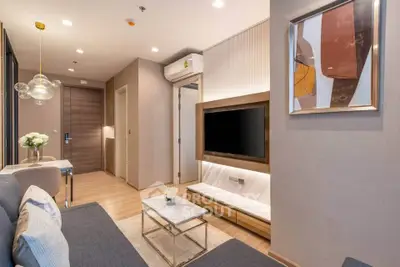 Modern living room with stylish decor and wall-mounted TV in a cozy apartment.