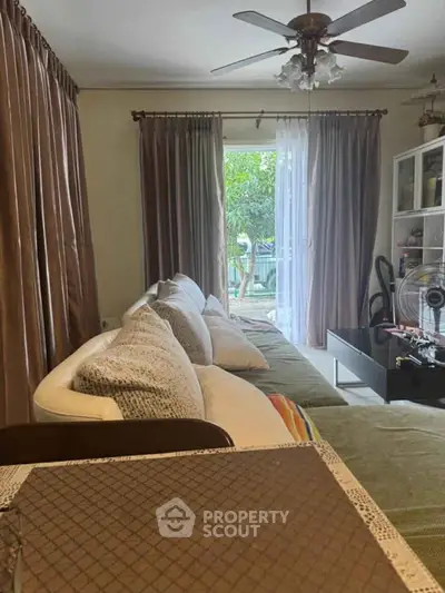 Cozy living room with large sofa and garden view, perfect for relaxation.