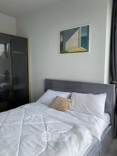 Modern bedroom with sleek design and ocean-themed artwork, featuring a cozy bed and stylish wardrobe.