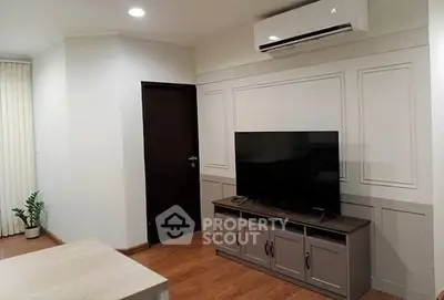 Modern living room with sleek TV setup and air conditioning unit