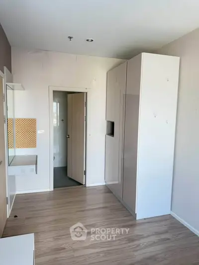 Modern minimalist bedroom with sleek wardrobe and wooden flooring