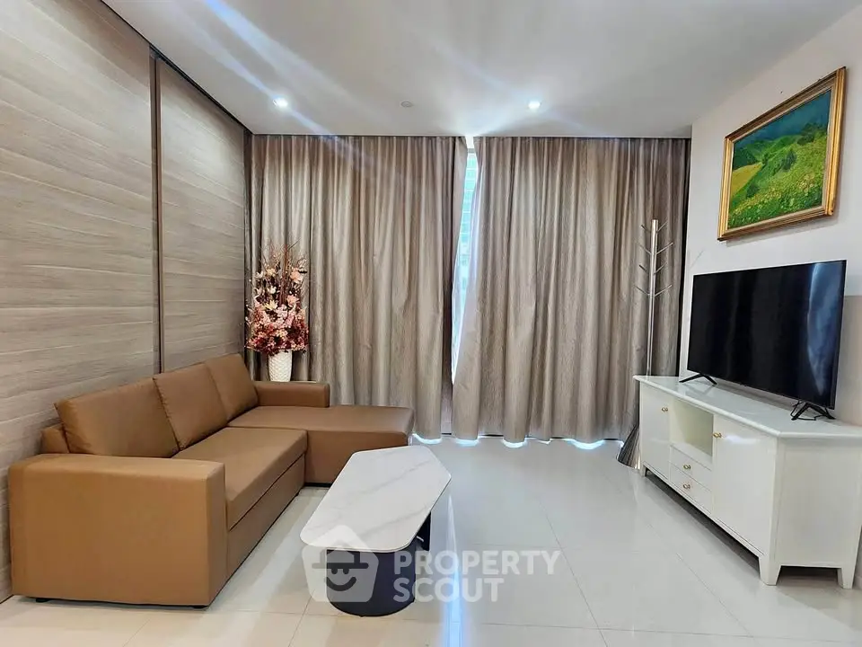 Modern living room with brown sofa, marble coffee table, and large TV, perfect for relaxation.