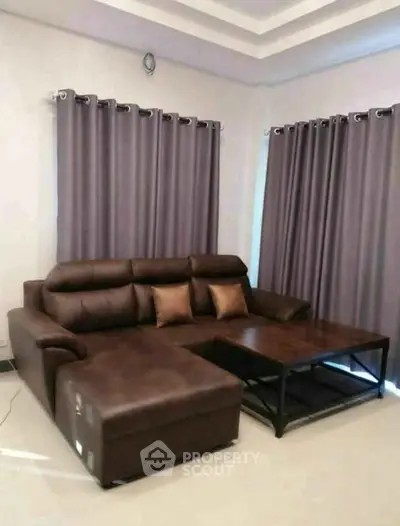 Stylish living room with modern brown leather sofa and elegant curtains