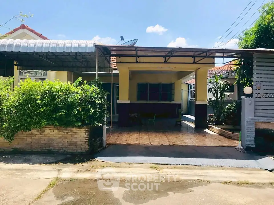 Charming single-story home with covered carport and lush greenery in a peaceful neighborhood.