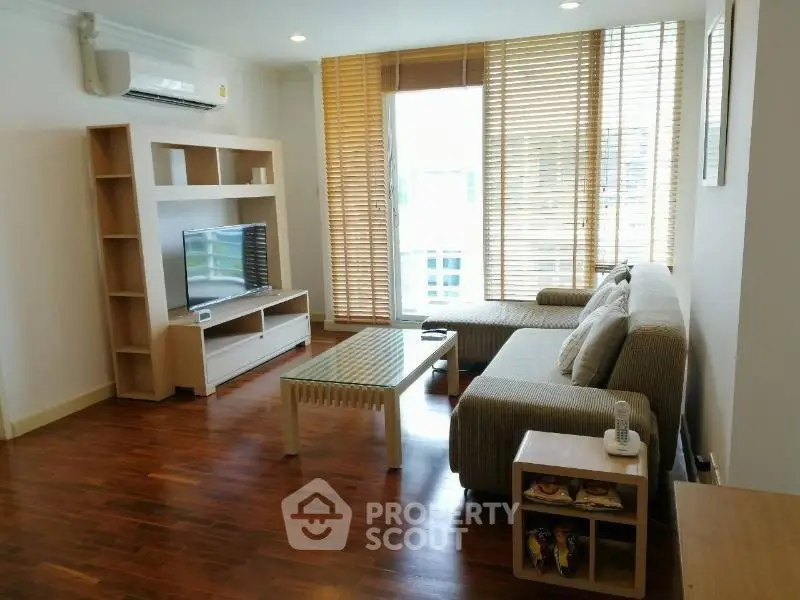 Spacious living room with modern furniture and large windows in a stylish apartment.