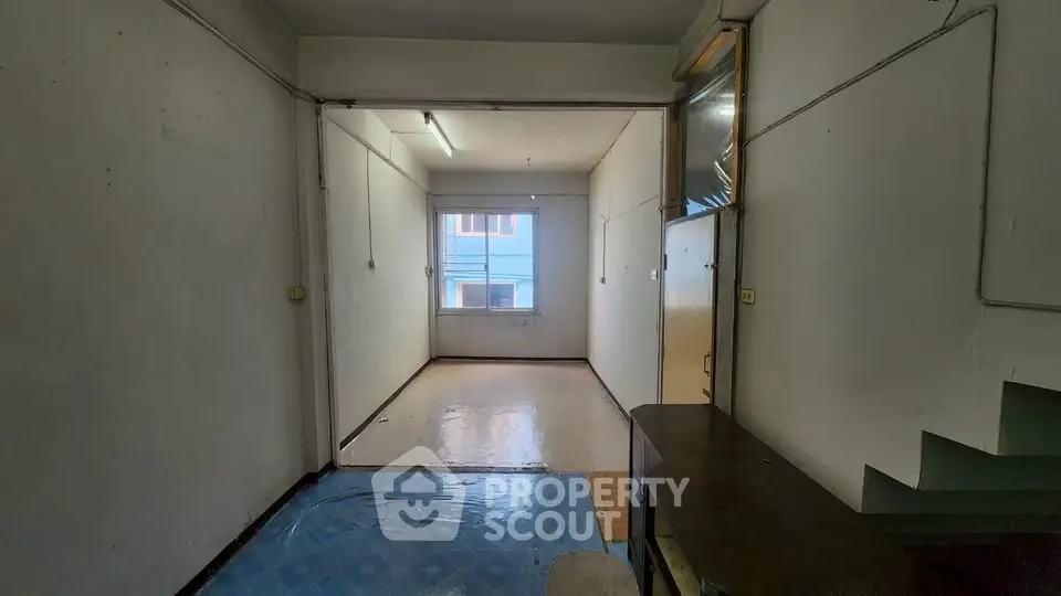 Spacious empty room with large window and natural light, ideal for customization.