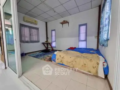 Cozy bedroom with simple decor and air conditioning in a bright home.