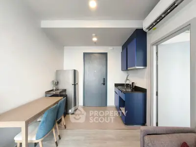 Modern kitchen with blue cabinets and dining area in a compact apartment