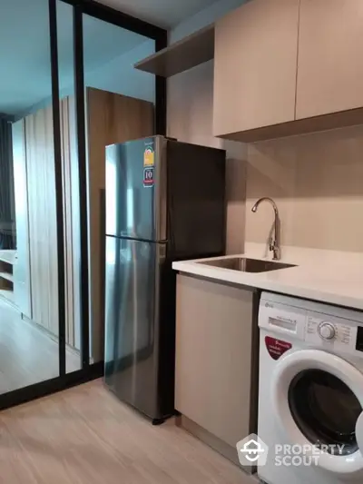 Modern kitchen with sleek appliances and stylish cabinetry in a contemporary apartment.