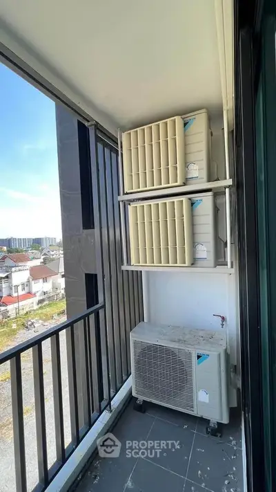 Compact balcony with air conditioning units and urban view