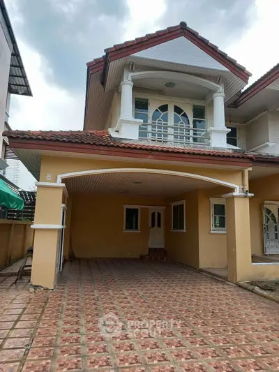 Charming two-story house with tiled driveway and elegant balcony.