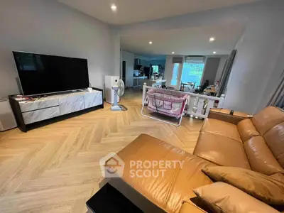 Spacious living room with modern decor and large TV, perfect for family gatherings.