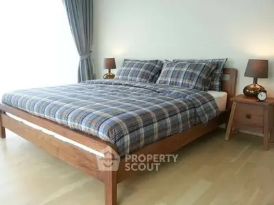 Cozy bedroom with plaid bedding and wooden furniture, perfect for relaxation.