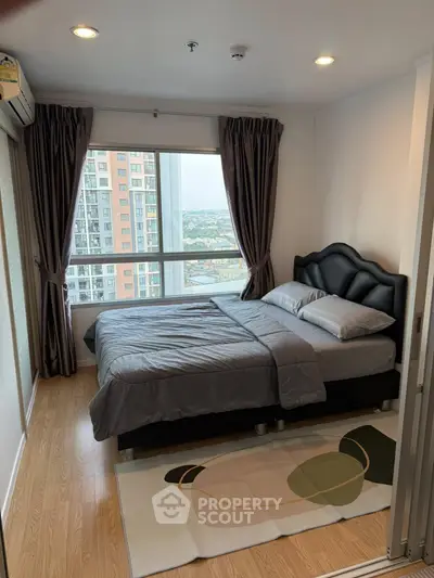 Modern bedroom with large window and city view in high-rise apartment