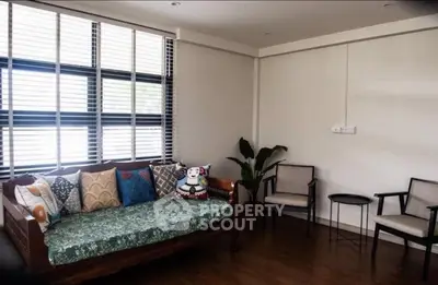 Charming living room with stylish furniture and large windows, perfect for relaxation and entertaining guests.