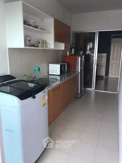 Modern kitchen with washing machine and microwave in a compact layout