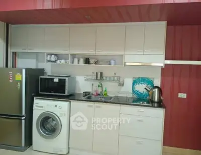 Modern kitchen with washing machine, fridge, and microwave in stylish apartment