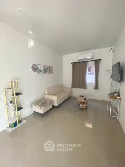 Modern living room with sleek furniture and wall-mounted TV, perfect for cozy gatherings.