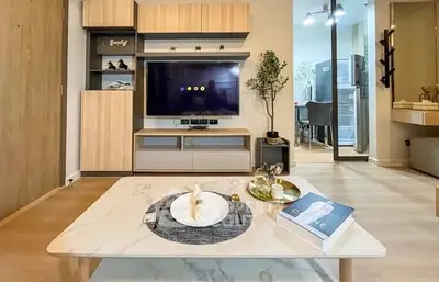 Modern living room with stylish decor and open layout, featuring a sleek TV setup and elegant coffee table.