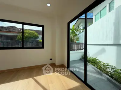 Bright room with large windows and garden view, perfect for a cozy living space.
