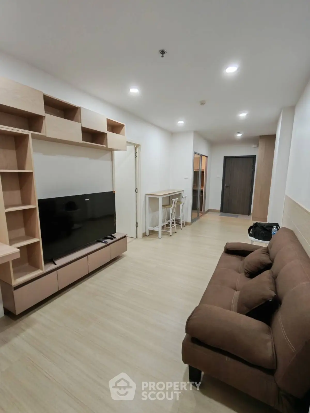Modern living room with sleek TV unit and cozy brown sofa