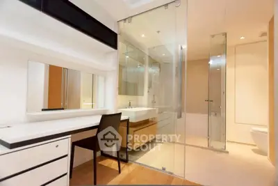 Modern bathroom with sleek glass shower and elegant vanity in luxury apartment.
