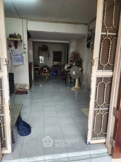 Spacious open-layout living area with tiled flooring and traditional decor, perfect for family gatherings.