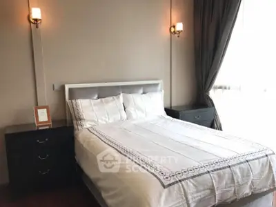 Cozy bedroom with elegant lighting and large window for natural light.