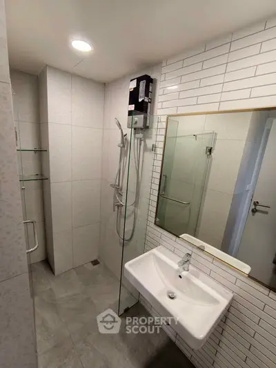 Modern bathroom with sleek shower and stylish sink in contemporary design.