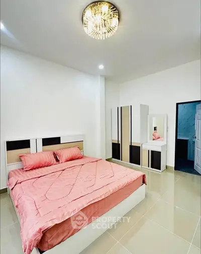 Modern bedroom with elegant chandelier and stylish furniture, featuring a cozy bed and sleek wardrobe.