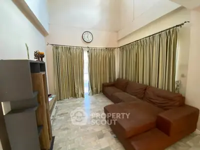 Spacious living room with cozy sectional sofa and elegant curtains