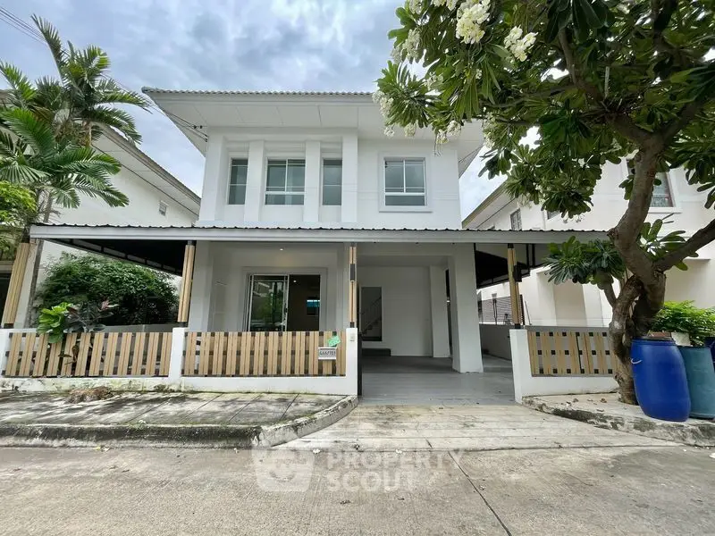 Charming two-story house with modern design and lush greenery in a serene neighborhood.