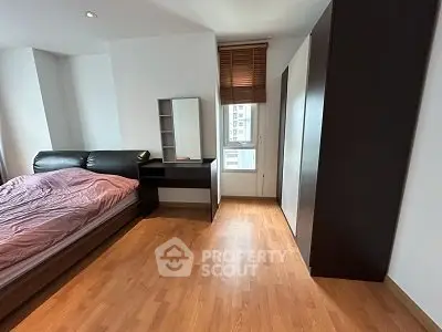 Spacious bedroom with modern furnishings and wooden flooring