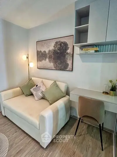 Cozy living room with stylish sofa, modern decor, and functional workspace in a chic apartment.