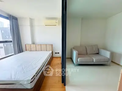 Modern studio apartment with separate bedroom and living area, featuring large windows and air conditioning.