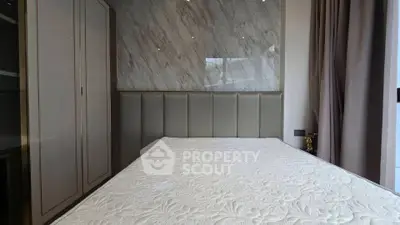 Luxurious bedroom with elegant marble accent wall and plush headboard