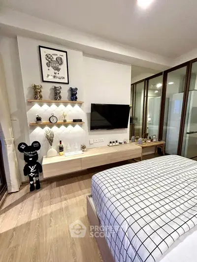 Modern bedroom with stylish decor and wall-mounted TV, featuring sleek wooden flooring and contemporary furnishings.