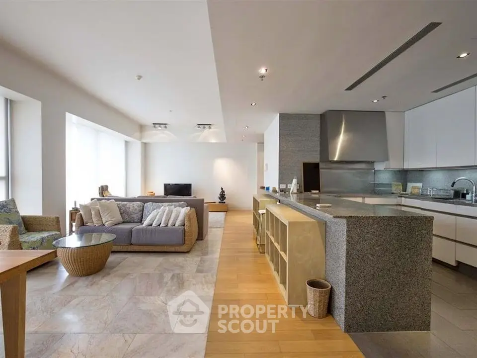 Spacious open-plan living room and kitchen with modern design and ample natural light.