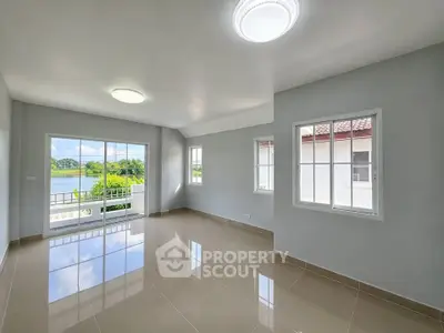 Spacious living room with large windows offering serene lake views in modern home.