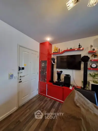 Modern living room with red shelving and wall-mounted TV, featuring stylish decor and wooden flooring.