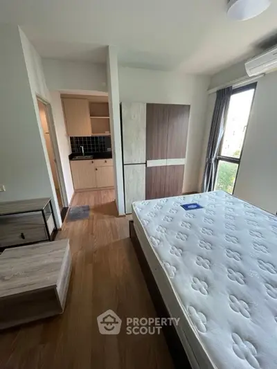 Modern bedroom with natural light and compact kitchen area