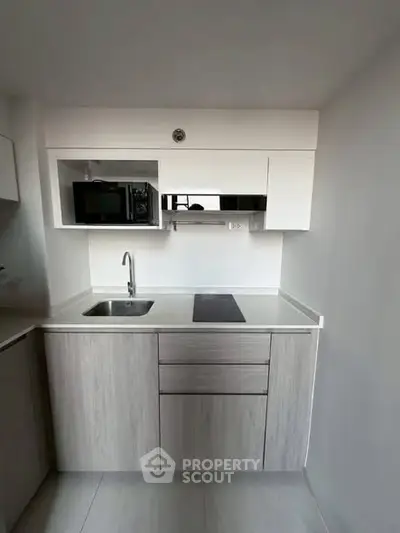 Modern compact kitchen with sleek cabinetry and built-in appliances in a minimalist design.