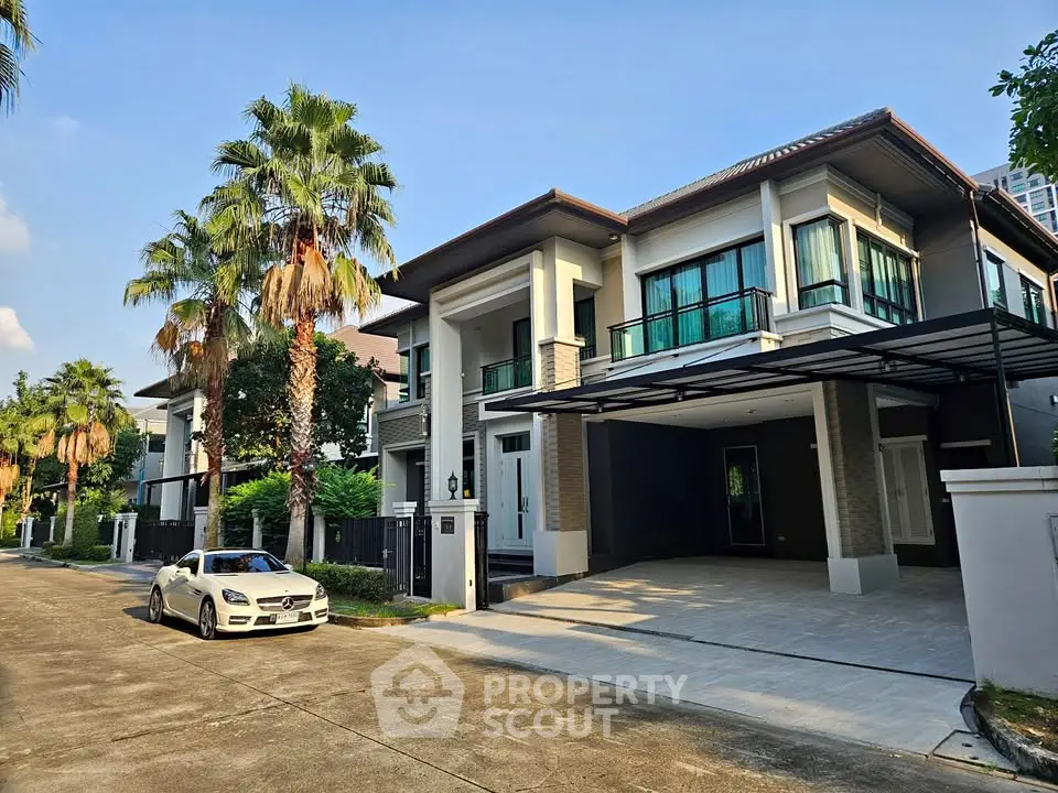 Luxurious modern house with spacious driveway and palm trees, perfect for upscale living.